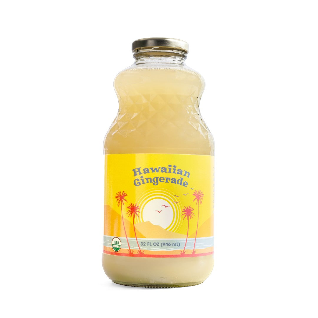 A 32 fl oz glass bottle of Big Island Organics Hawaiian Gingerade with a yellow label featuring a sun, palm trees, and a gold cap
