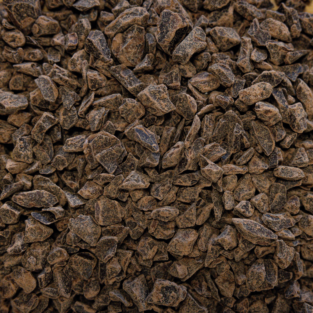 A close-up image of TCHO dark chocolate chunks showing their textured and irregular shape.
