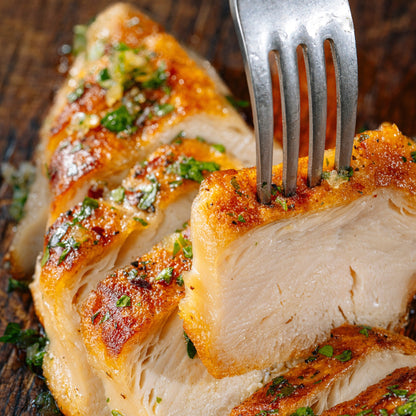 A close up of a sliced SWAP Chicken filet. A fork is poked into one piece and is pulling it away from the other pieces.